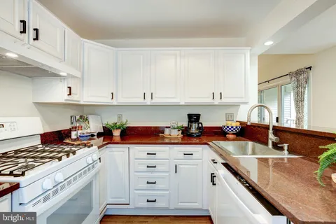 a kitchen with stainless steel appliances granite countertop a sink stove and cabinets