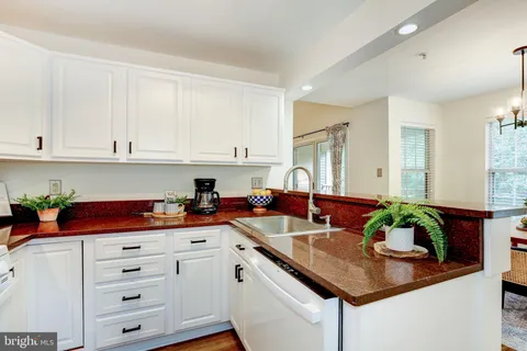 a kitchen with stainless steel appliances granite countertop a sink a stove and cabinets