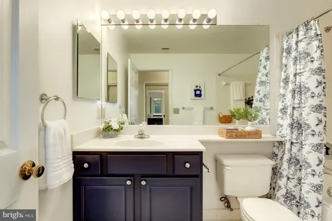 a bathroom with a sink a toilet and mirror