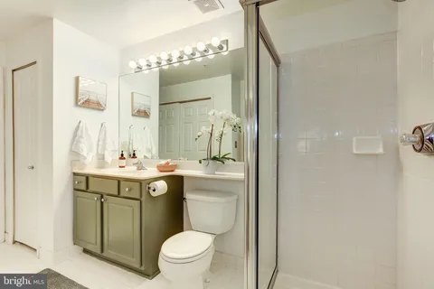 a bathroom with a granite countertop toilet sink and mirror