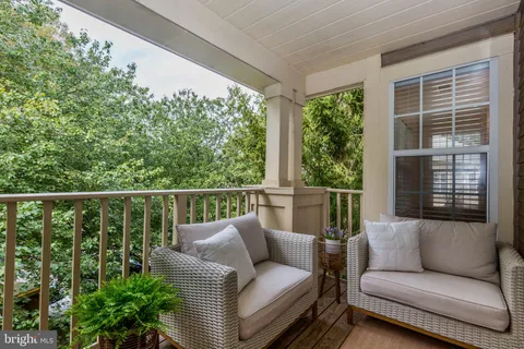 a balcony with furniture and a potted plant