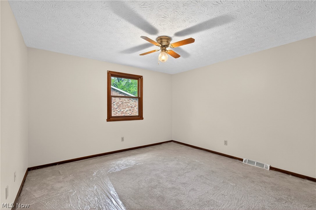 5346 Burlawn Street Northwest Canton, OH 44708 - Photo 23 of 40 Room featuring a single window with wood trim, a ceiling fan with integrated lighting, and neutral wall paint