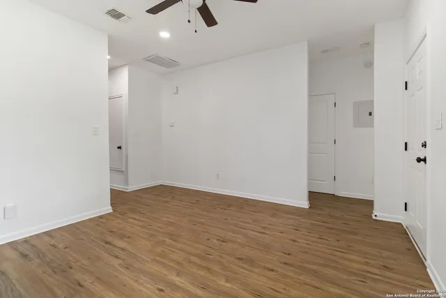a view of an empty room with wooden floor