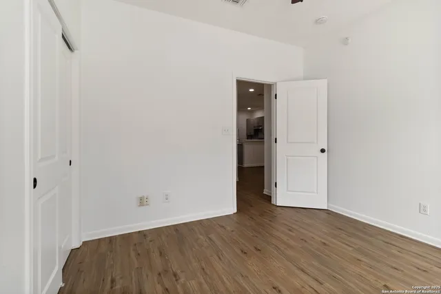 a view of empty room with wooden floor