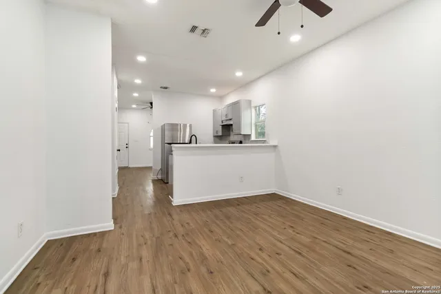 a view of a kitchen with a sink and wooden floor