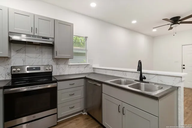 a kitchen with granite countertop white cabinets and appliances