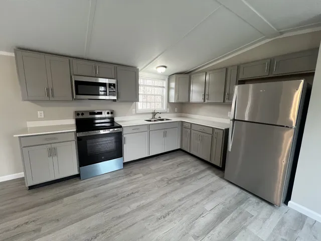 a kitchen with stainless steel appliances a refrigerator sink and microwave