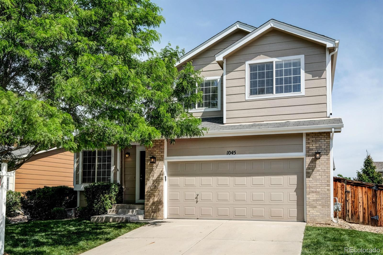 1045 Riddlewood Lane Highlands Ranch, CO 80129 - Photo 1 of 26 a view of house with a yard and large tree