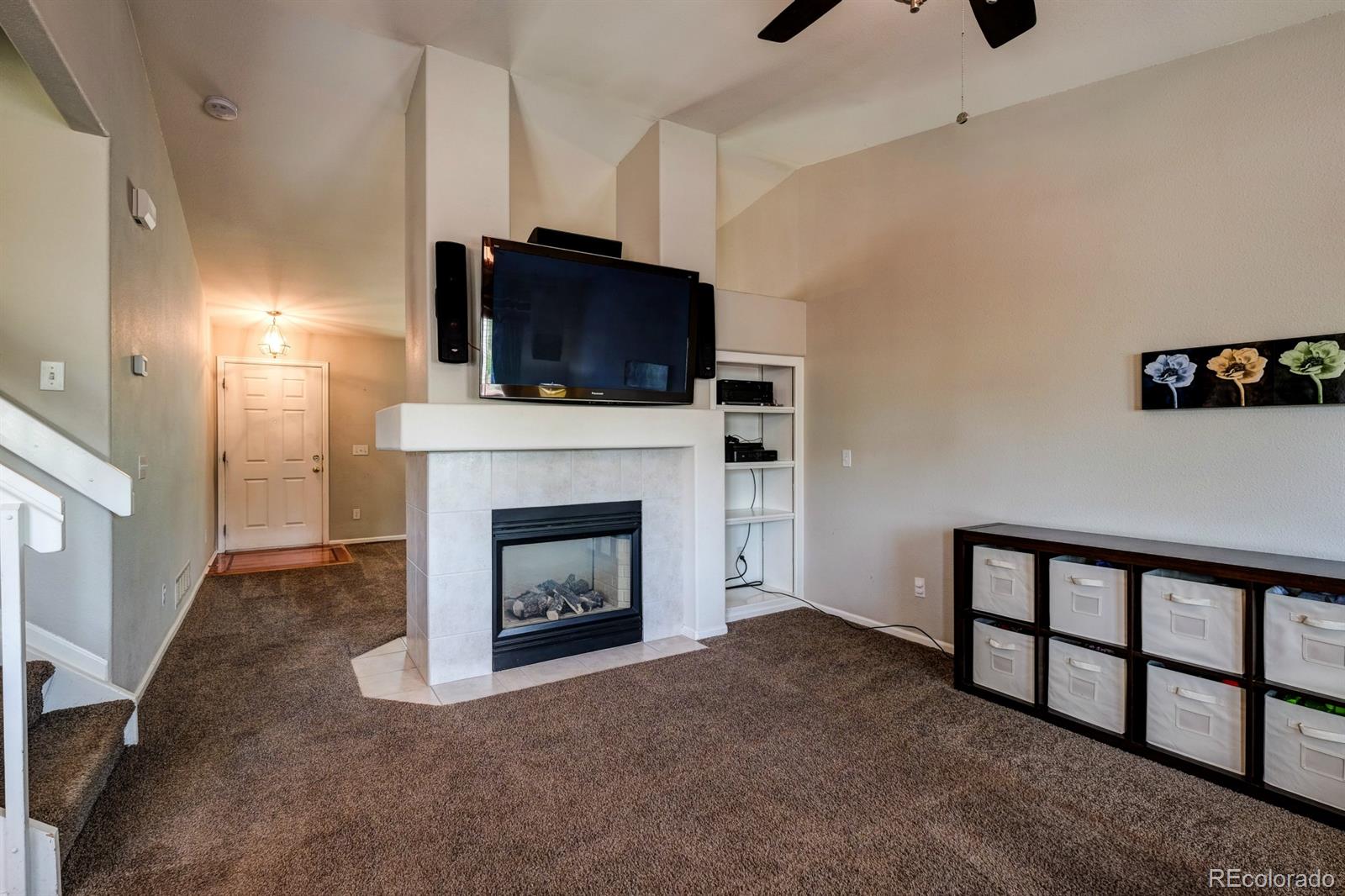 1045 Riddlewood Lane Highlands Ranch, CO 80129 - Photo 12 of 26 a living room with furniture a flat screen tv and a fireplace