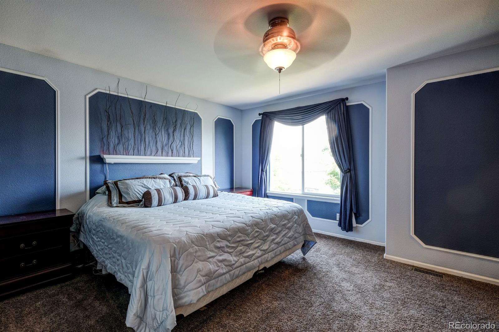 1045 Riddlewood Lane Highlands Ranch, CO 80129 - Photo 16 of 26 a bedroom with a large bed and a large window