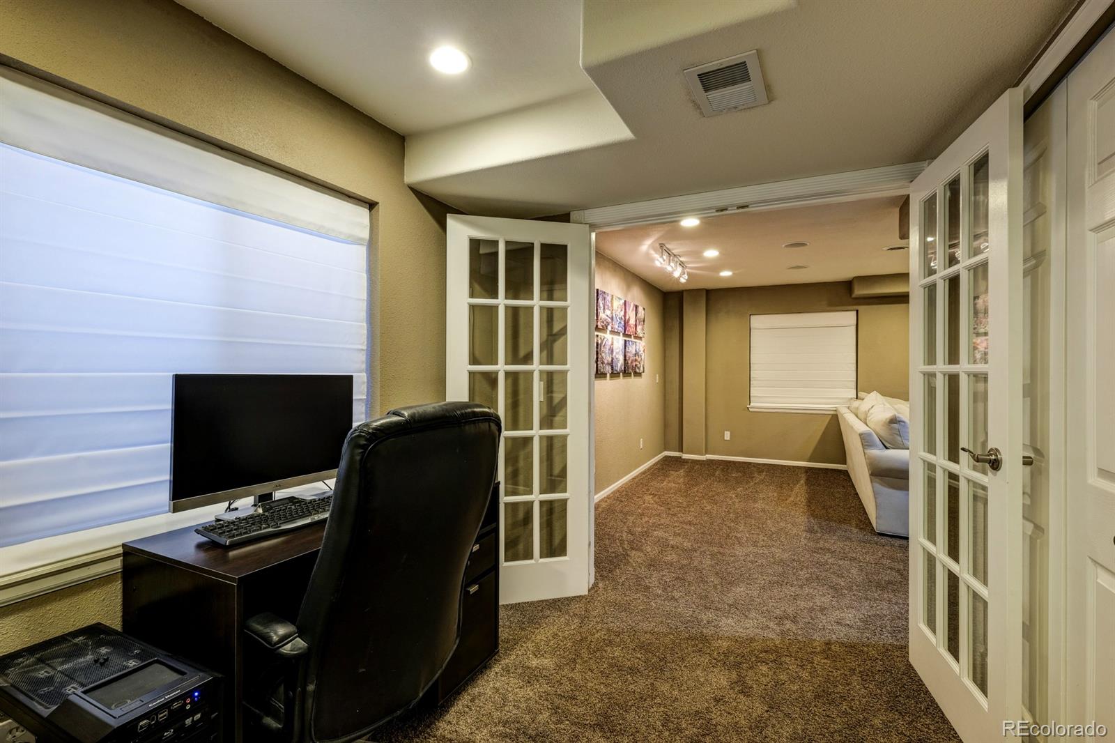 1045 Riddlewood Lane Highlands Ranch, CO 80129 - Photo 20 of 26 a living room with furniture and a flat screen tv