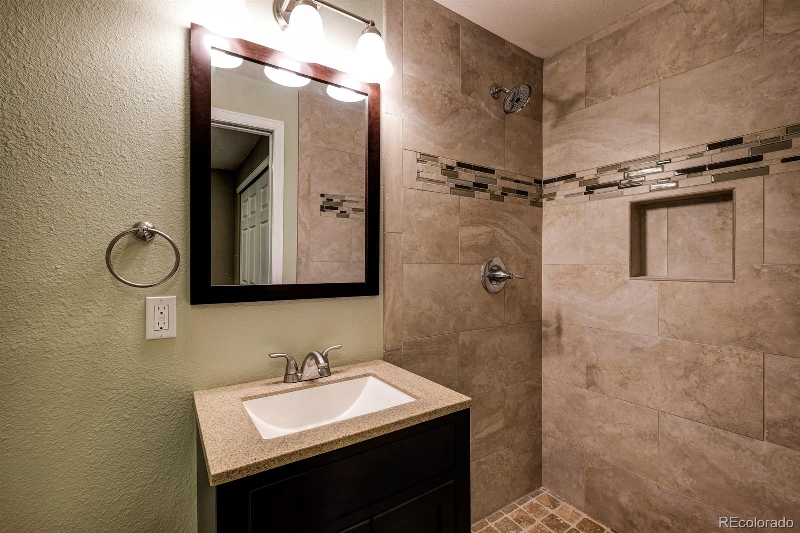 1045 Riddlewood Lane Highlands Ranch, CO 80129 - Photo 23 of 26 a bathroom with a sink vanity and a mirror