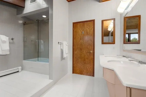 a bathroom with a tub sink and mirror