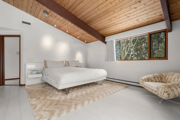 a spacious bedroom with a bed and a window