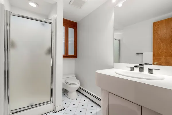 a bathroom with a sink a toilet and shower