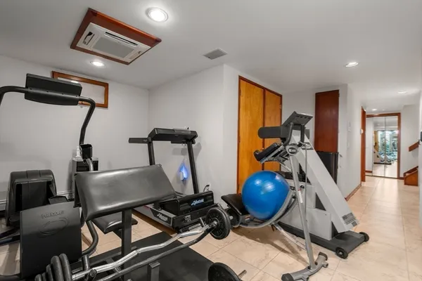 a room with gym equipment and wooden floor
