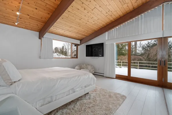 a spacious bedroom with a large bed and a large window