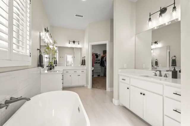 a bedroom with a large bed and a flat tv screen on dresser