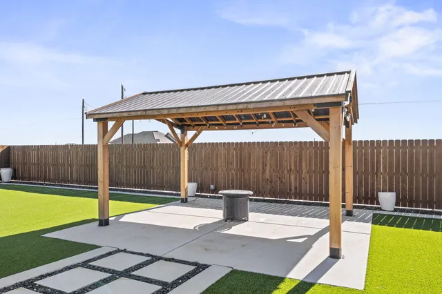 a patio with a table and chairs under an umbrella