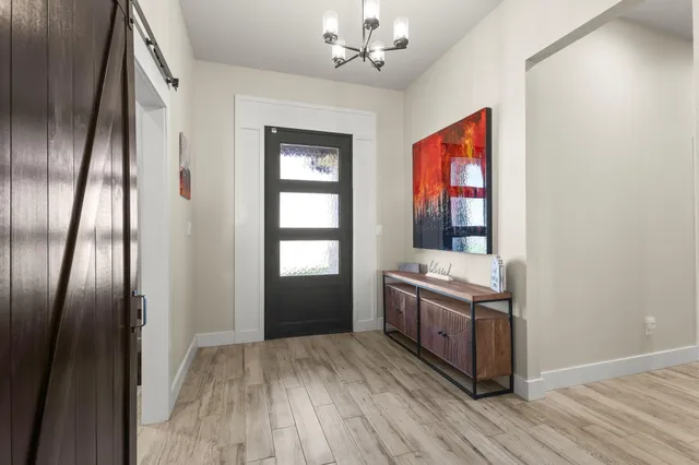 an empty room with wooden floor cabinet and windows