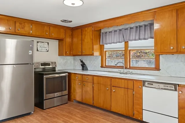 a kitchen with stainless steel appliances granite countertop a refrigerator and a sink