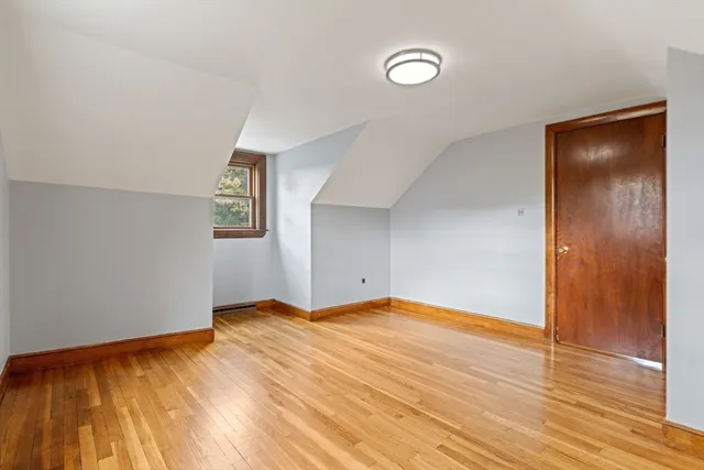 a view of an empty room with wooden floor and closet