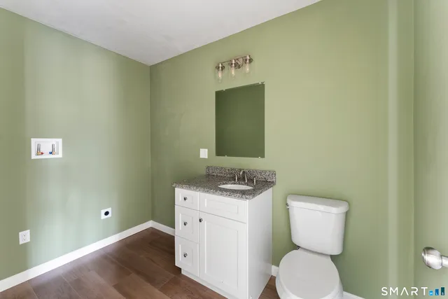 a kitchen with granite countertop a sink and white cabinets