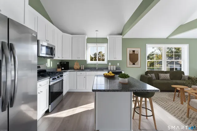 a kitchen with granite countertop a refrigerator stove top oven and sink
