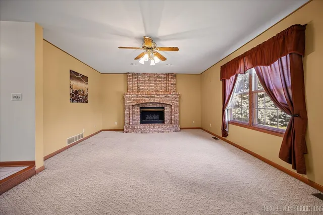 an empty room with windows and fireplace