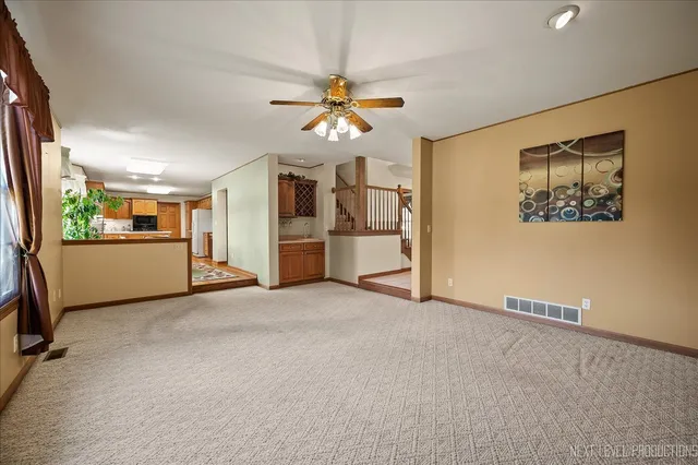 an empty room with windows and ceiling fan