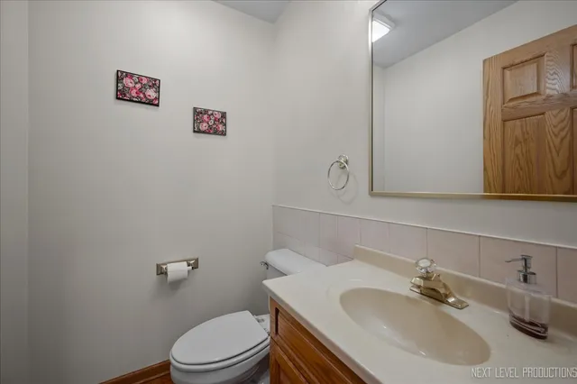 a bathroom with a sink vanity mirror and toilet