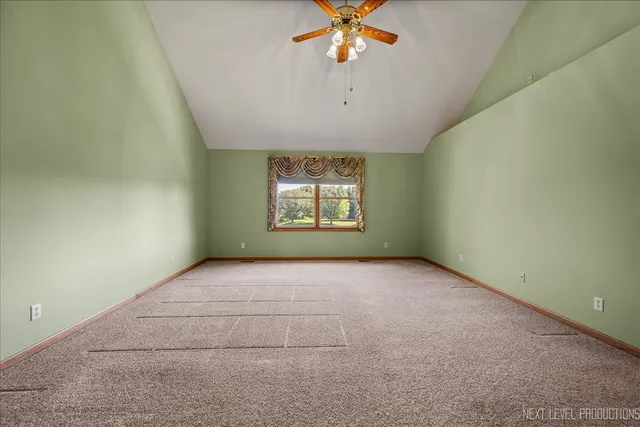an empty room with a window and a ceiling fan