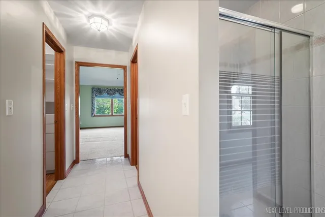 a view of hallway with chandelier fan