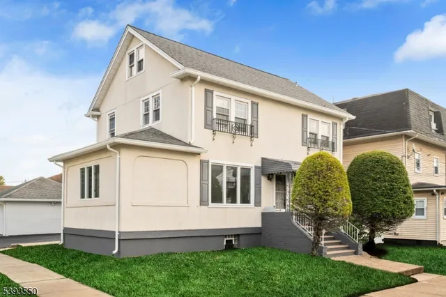 a view of a white house next to a yard