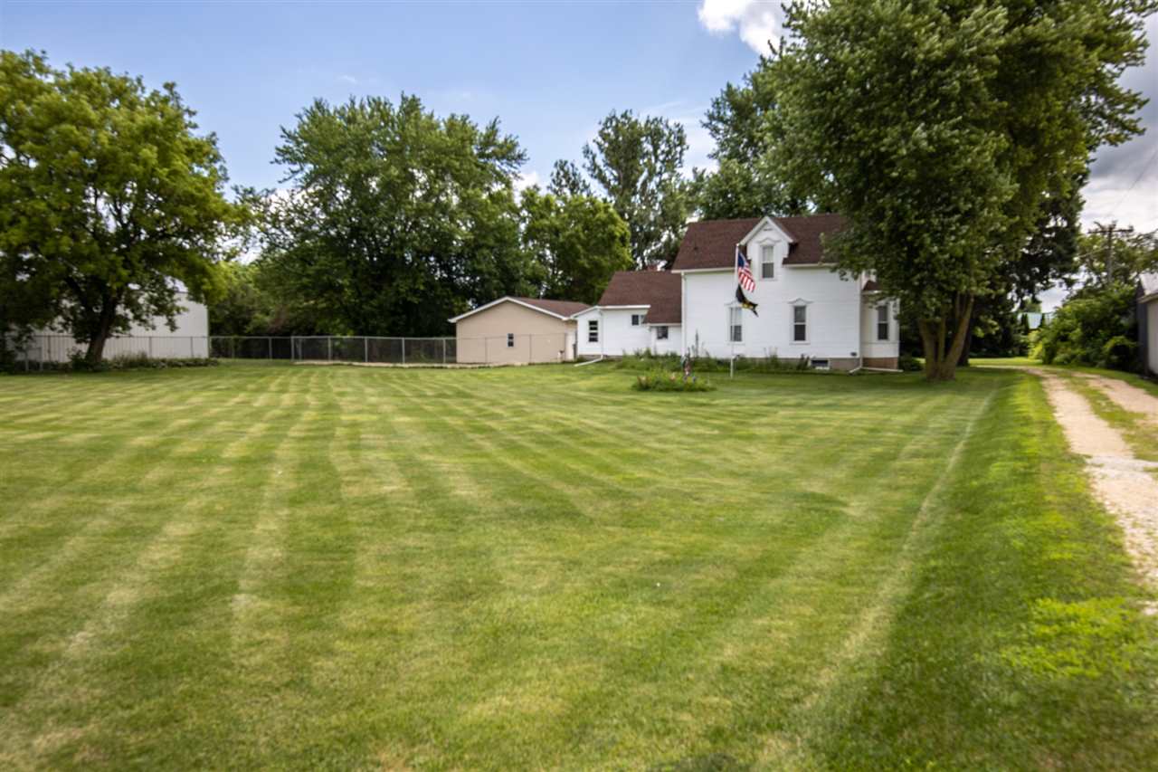 6975 Garden Prairie Road Garden Prairie, IL 61038 - Photo 1 of 28 a backyard of a house with plants and large trees