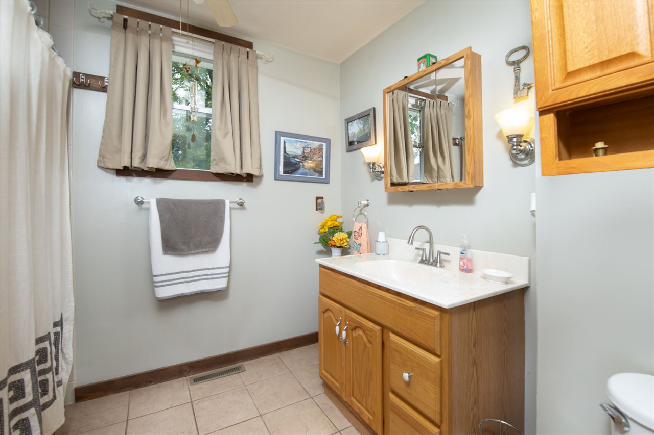 6975 Garden Prairie Road Garden Prairie, IL 61038 - Photo 15 of 28 a bathroom with a sink vanity and a mirror