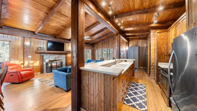 a kitchen with furniture a refrigerator and a view of living room