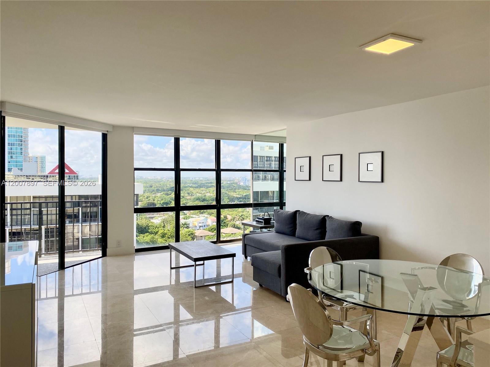 1901 Brickell Avenue, Unit B2007 Miami, FL 33129 - Photo 2 of 11 a living room with furniture and a floor to ceiling window