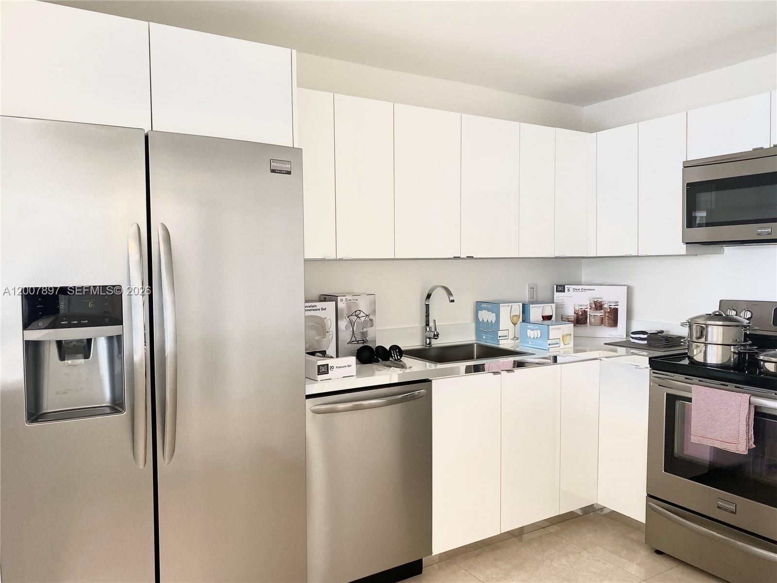 1901 Brickell Avenue, Unit B2007 Miami, FL 33129 - Photo 5 of 11 a kitchen with stainless steel appliances granite countertop a refrigerator sink and white cabinets