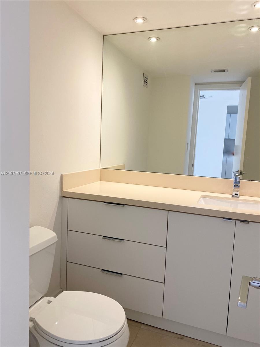 1901 Brickell Avenue, Unit B2007 Miami, FL 33129 - Photo 6 of 11 a bathroom with a sink a toilet and mirror