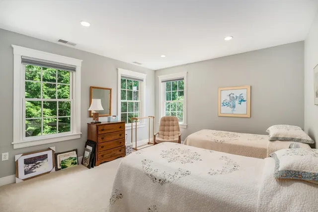 a bedroom with a bed and a dresser next to a window