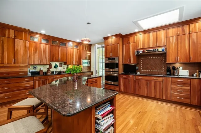 a kitchen with stainless steel appliances granite countertop a stove a sink and a microwave
