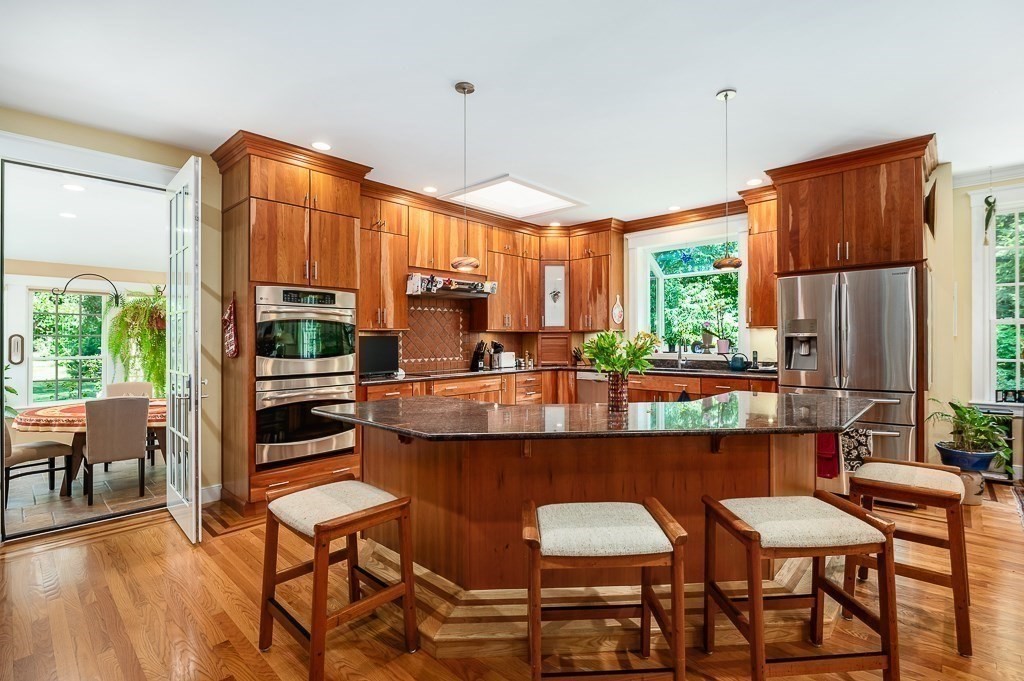 12 Wallis Drive, Unit 12 Wenham, MA 01984 - Photo 8 of 35 a kitchen with a table chairs stove and cabinets