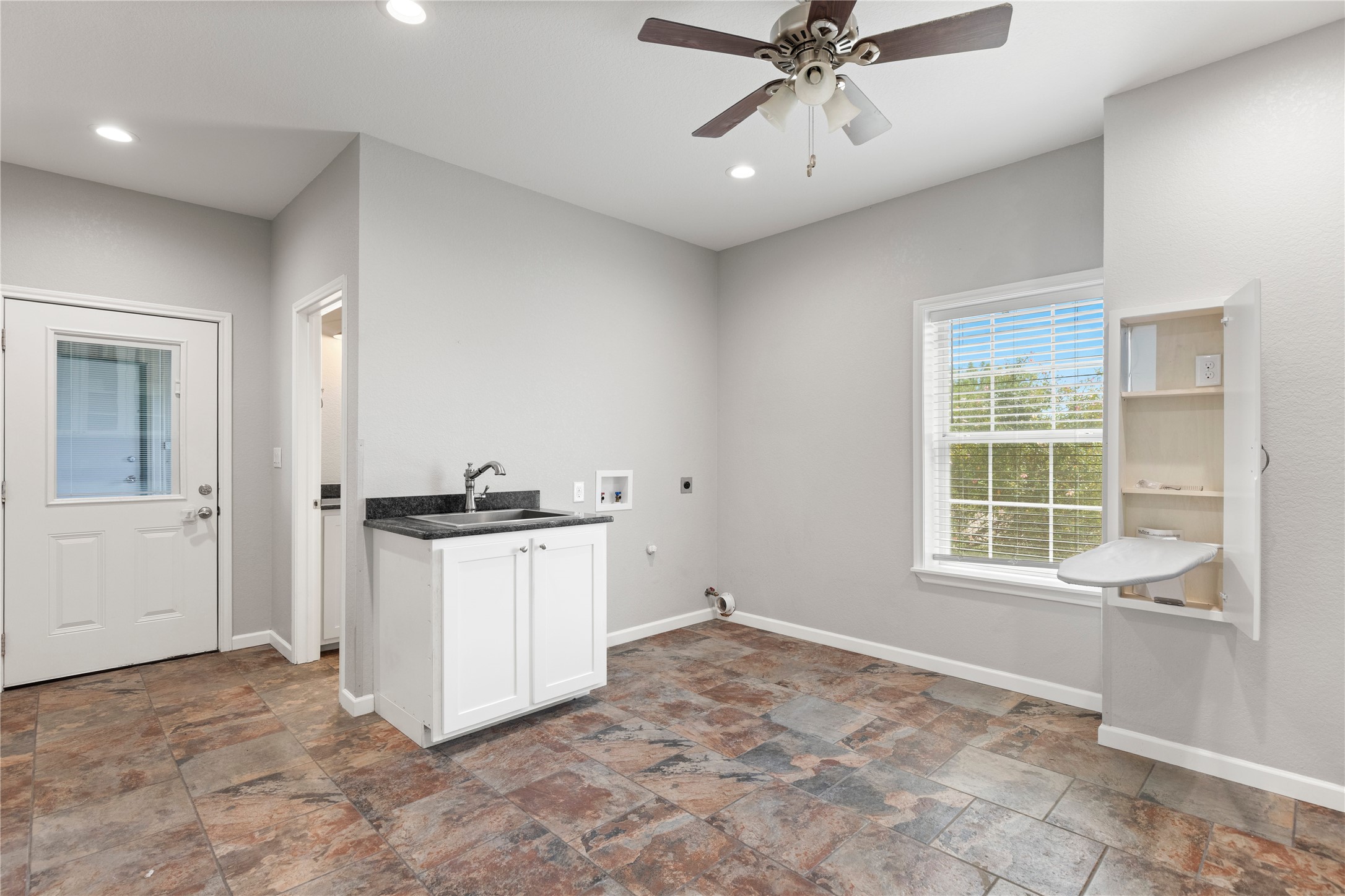 1293 Pioneer Road Seguin, TX 78155 - Photo 12 of 40 Functional utility space, complete with a convenient sink, cabinet storage, and ample natural light.