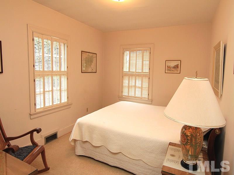 2009 Banbury Road Raleigh, NC 27608 - Photo 22 of 24 a bedroom with a bed and wooden floor