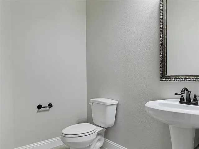a white toilet sitting next to a bathroom sink