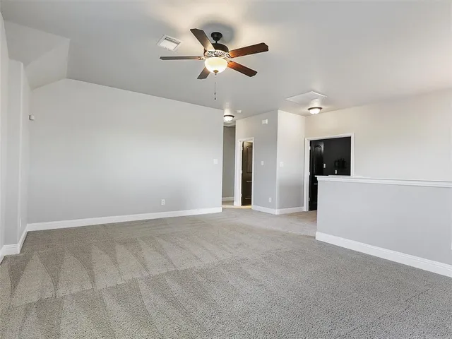 a view of an empty room with a ceiling fan