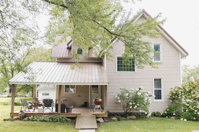a front view of a house with a garden and sitting area