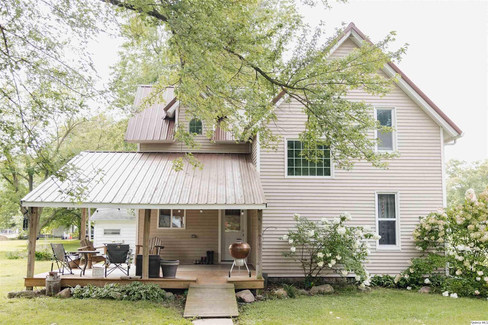 a front view of a house with a garden and sitting area