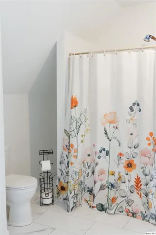 a bathroom with a toilet and a shower curtain